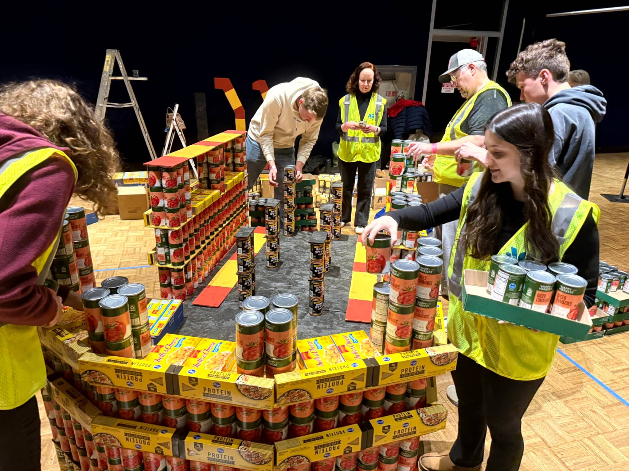 The AG team keeps the canstruction sculpture straight and steady. 