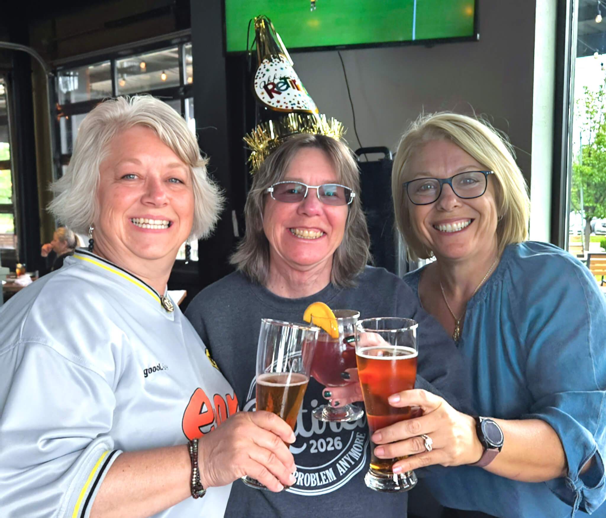 Marcia Volstorf, Cindy Lofy and Katie Miller celebrate Cindy with drink cheer during her retirement party in 2026.
